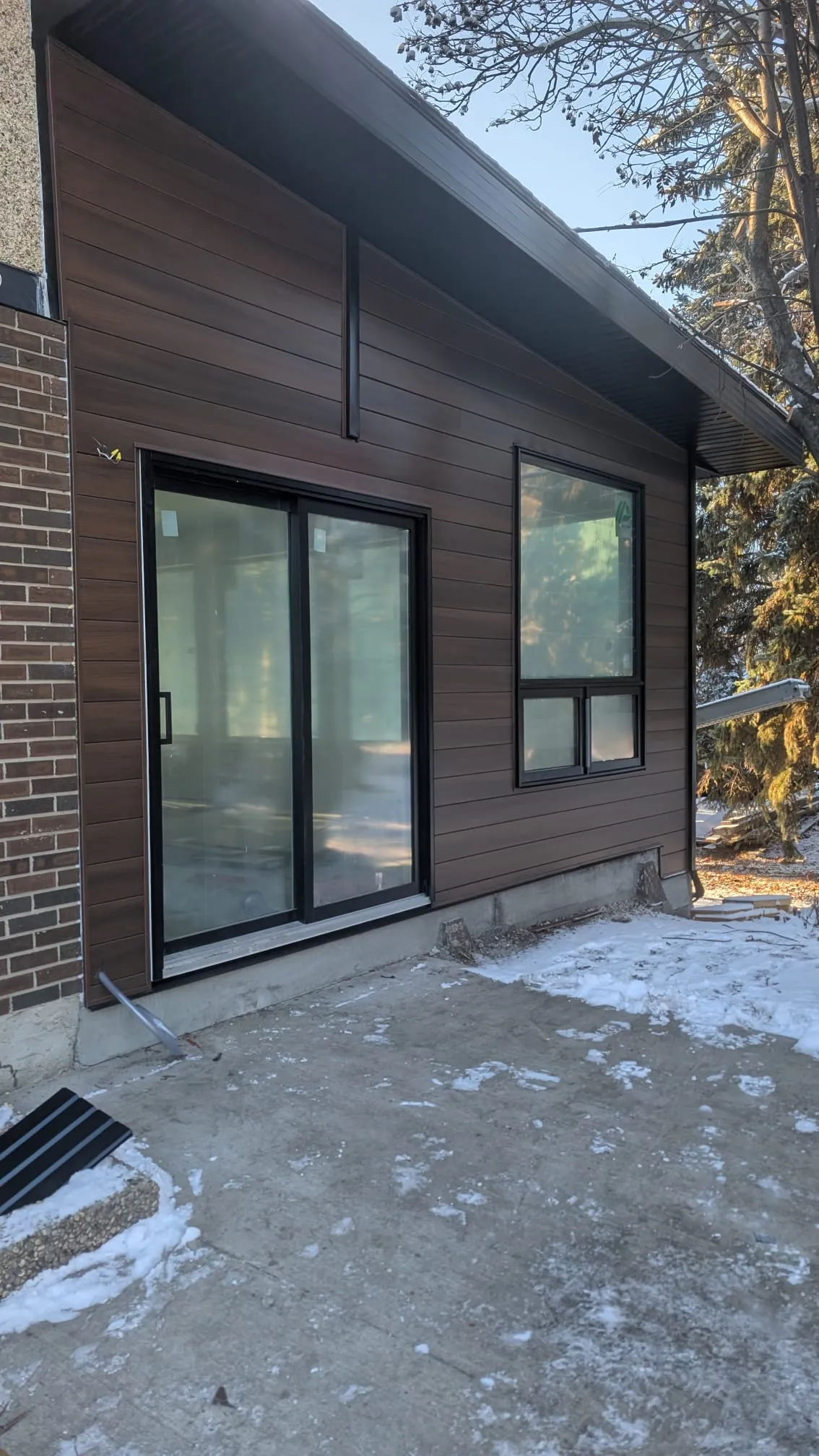 ACR Construction finished dark siding patio area with sliding doors